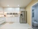 Modern kitchen with white cabinets, stainless steel appliances, and adjacent bathroom