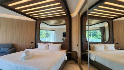 Modern bedroom with double bed, wooden decor, and large mirrors