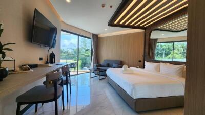 Spacious bedroom with large windows, comfortable bed, and modern furnishings