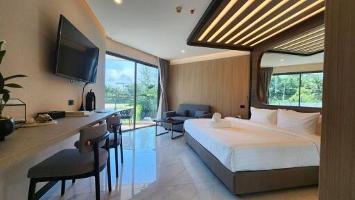 Spacious bedroom with large windows, comfortable bed, and modern furnishings