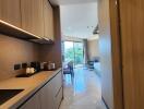 Modern kitchen with wooden cabinets and view of living space