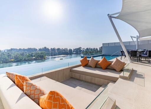 Outdoor lounge area with pool and lake view