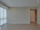 Empty modern living room with hardwood floor and large windows