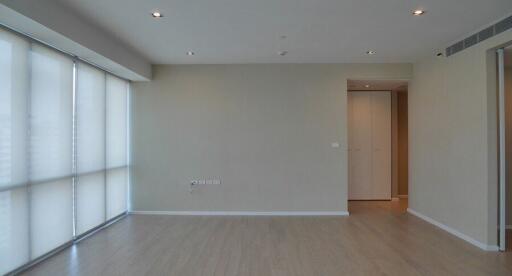 Empty modern living room with hardwood floor and large windows