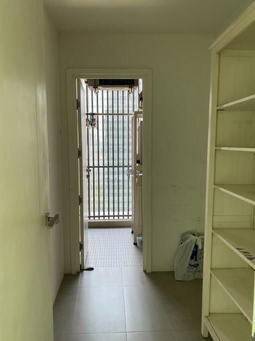 Utility room with a doorway leading to a balcony