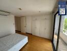 Bedroom with wooden floors, large window, and built-in wardrobes