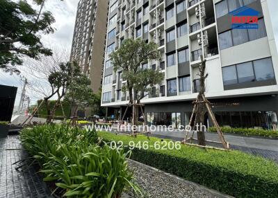 Front view of the apartment building with greenery