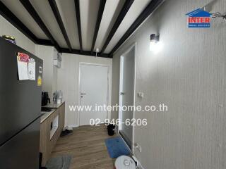 Modern kitchen with black refrigerator, white cabinets, and wood flooring