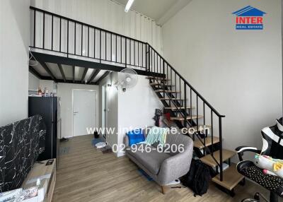 Modern living room with a mezzanine, staircase, and couch