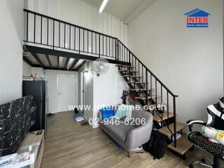 Modern living room with a mezzanine, staircase, and couch