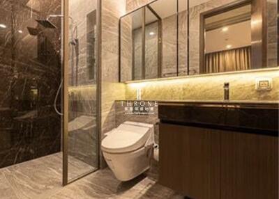 Modern bathroom with glass shower enclosure and mounted toilet
