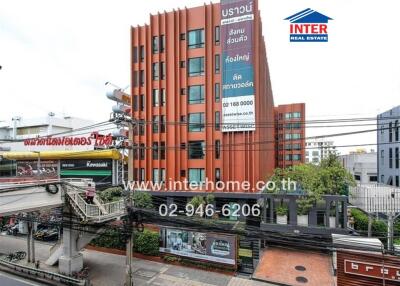 Red commercial building with contact details on a banner in the foreground