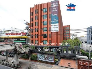 Red commercial building with contact details on a banner in the foreground