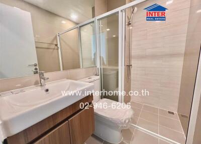 Modern bathroom with a glass shower, sink, and toilet