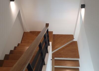Modern wooden staircase with wall-mounted lights