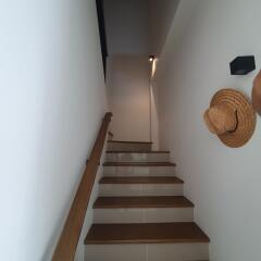 Staircase with wooden steps and wall-mounted hats