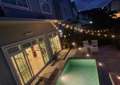 Outdoor area with a swimming pool and string lights