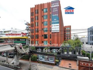 Front view of a multistory building with signage and contact information