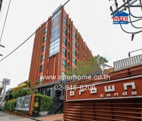 Condominium building exterior with signage and surrounding area