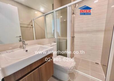 Modern bathroom with a glass shower, a vanity with sink, and tiled walls