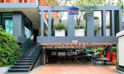 Modern building entrance with parking area and signage