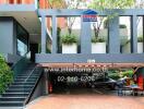 Modern building entrance with parking area and signage