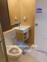 Modern bathroom with sink, toilet, and mirror