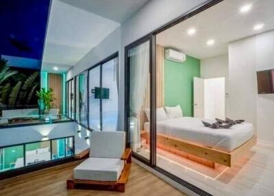 Modern bedroom with large glass walls, balcony view, and minimalistic design