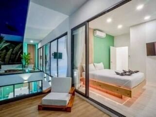 Modern bedroom with large glass walls, balcony view, and minimalistic design