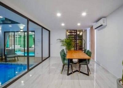 modern dining area adjacent to the pool with glass sliding doors