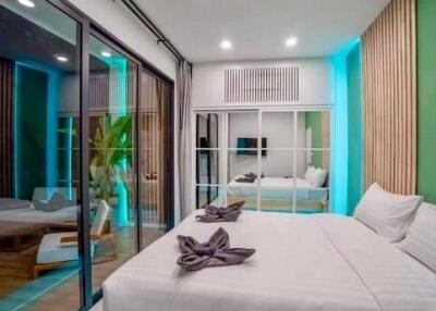 Modernly decorated bedroom with a large bed and sliding glass doors to the balcony
