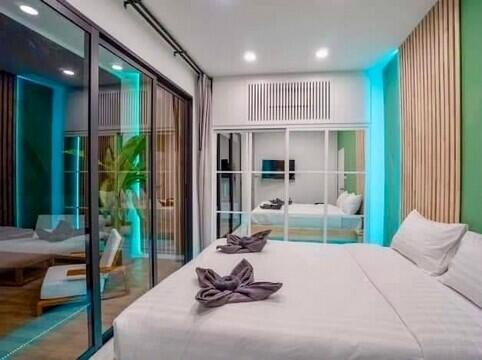 Modernly decorated bedroom with a large bed and sliding glass doors to the balcony