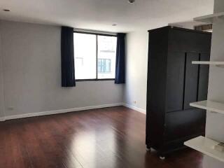 Spacious empty living room with wooden floor and large window