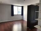 Spacious empty living room with wooden floor and large window