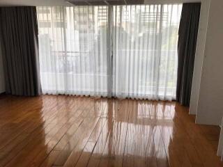 Spacious living room with large windows and wooden flooring