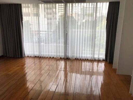 Spacious living room with large windows and wooden flooring