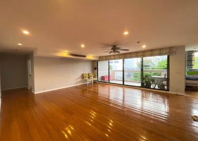 Spacious living room with wooden flooring and large windows