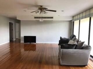 Spacious living room with wooden flooring and large windows