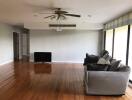 Spacious living room with wooden flooring and large windows