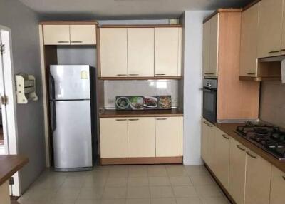 Modern kitchen with beige cabinets, stainless steel refrigerator, and gas stove