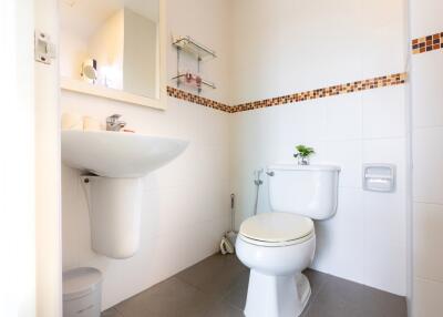 Small bathroom with white fixtures and decorative tile