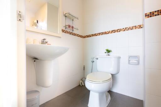 Small bathroom with white fixtures and decorative tile