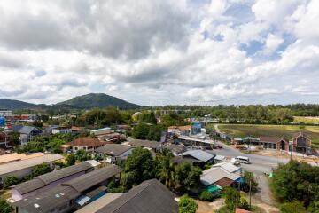 Aerial view of residential area with surrounding greenery and distant hills