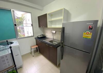 Compact kitchen with stainless steel fridge and dark cabinetry
