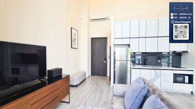 Modern living area with TV, kitchen, and air conditioning unit