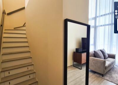 Living room view with staircase and large window