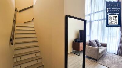 Living room view with staircase and large window