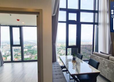 Living area with dining table and large windows with city view