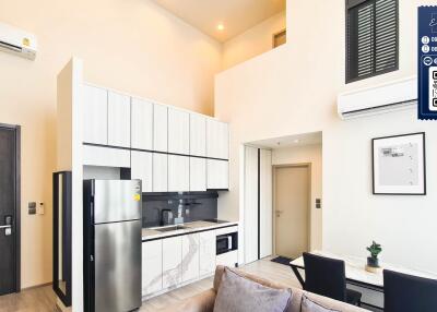 Modern kitchen area with dining table, air conditioner, and high ceiling