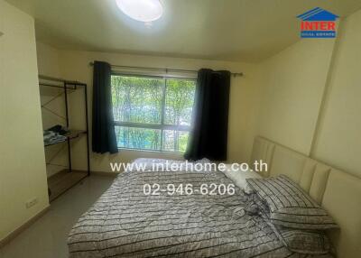 Bedroom with bed, window and shelving unit